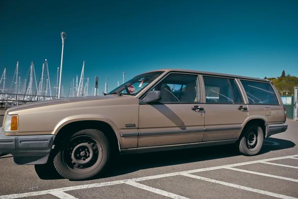 a brown volvo station wagon in profile faces left
