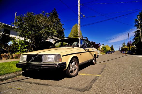 a Volvo parked on the street pointing slightly towards the camera. The clear blue sky is behind