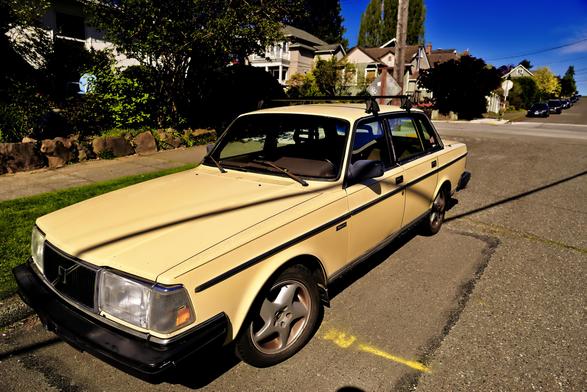 A Volvo sedan is parked on the street and facing toward the camera