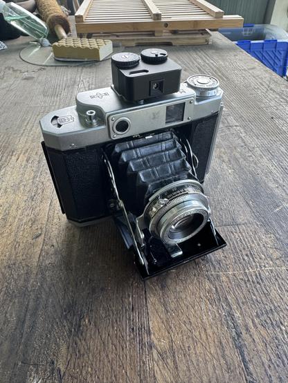 Mamiya 6V folding camera, bellows open, with a light meter in the cold shoe.