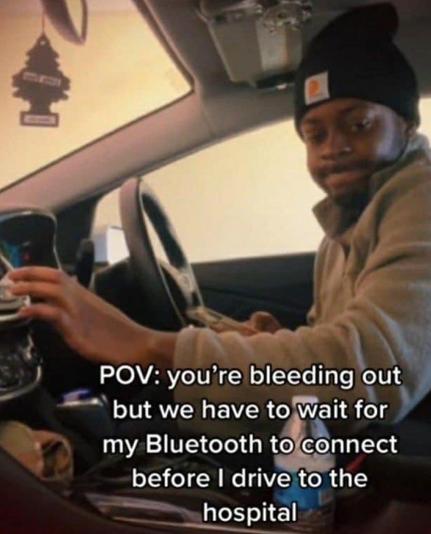 a guy in a car looking embarrassed and the text says POV: you're bleeding out but we have to wait for my Bluethooth to connect before I drive to the hospital