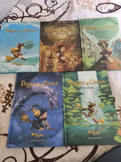 Image of five Pepper & Carrot comic books laying on my bed.