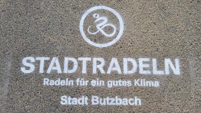 Werbung auf einem Feldweg für das Stadtradeln. Kreidespray und eine Schablone hilft.
