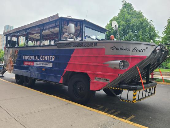 Imposing six wheeled Boston Duck tour bus/boat thing. In big letters: PRUDENTIAL CENTER, as in the life ensurance company.

PRUBOSTON
DISCOVERY AWAITS

 In little letters: "Prudence Center" I think they forgot a few letters