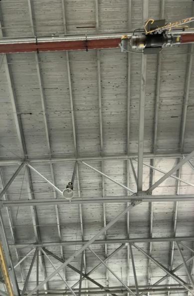 Far away roof made of 2x4 lumber.  The red and yellow of the overhead crane pops in contrast to the roof.