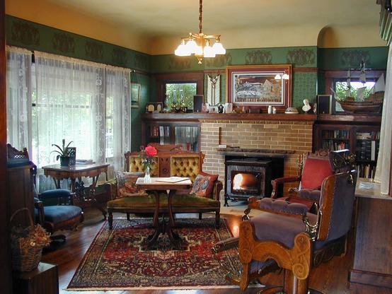 Living room of a 1914 bungalow decorated with historic wallpaper and antique furniture.