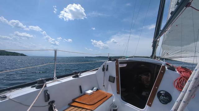 View from the boat. The lake stretches into the haze in front of the Alps.