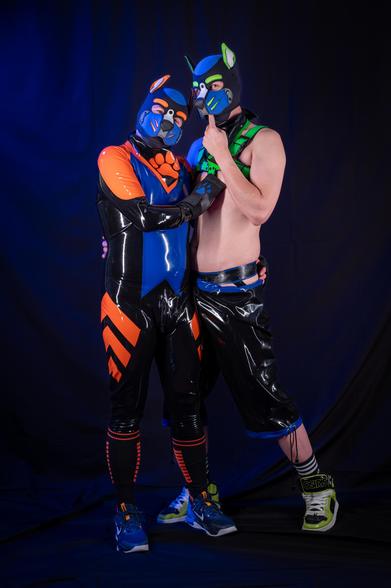 Two human pups in rubber, Nigel looking mischievous, shadow looking dumb and happy.
