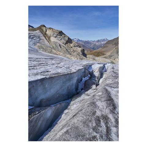 Photo d'un paysage de haute-montagne.
Au premier plan le regard est plongé dans une crevasse peu profonde d'un glacier, qui file vers la vallée. La glace est grisâtre avec quelques taches de neige.
L'horizon est fermé par des montagnes, le paysage est minéral, le ciel est bleu, à peine voilé.
-
Photo of a high-mountain landscape.
In the foreground, the viewer’s gaze is drawn to a shallow crevasse in a glacier that stretches down toward the valley. The ice is grayish with a few patches of snow.
The horizon is framed by mountains; the landscape is rugged; the sky is blue, barely veiled.