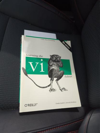 The sixth edition Learning the vi editor book from O'Reilly, sitting on my car seat.