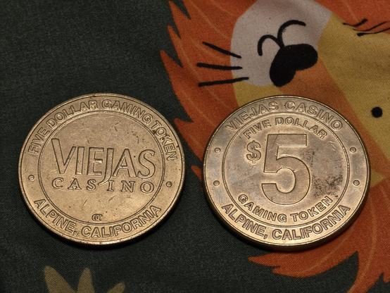 Two $5 casino tokens from the Viejas Casino, showing the obverse and reverse.