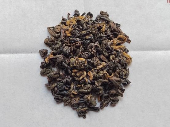 This closeup view of the tea shows the fine structure of the rolled and curled leaves, showing off the complicated coloration of differing degrees of oxidation.