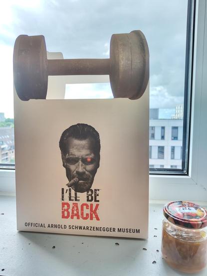 Un tarro de mermelada de... Se me ha olvidado, y una bolsa del museo de Schwarzenegger con una foto del austriaco con un ojo a lo Terminator y fumando un puro.
Y las asas son pesas