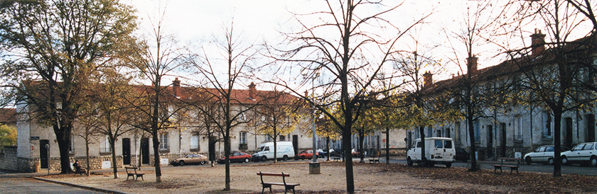 A photo of a city square with trees and benches.