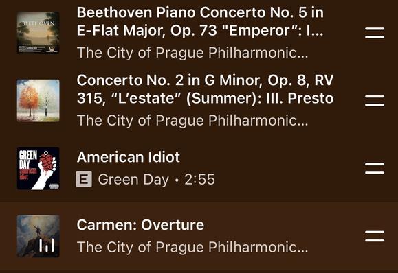 A segment of a YouTube Music queue listing a piece of Beethoven’s seventh symphony, a piece from Vivaldi’s Four Seasons, and the overture to Carmen. Also in the queue between these pieces is Green Day’s American Idiot.