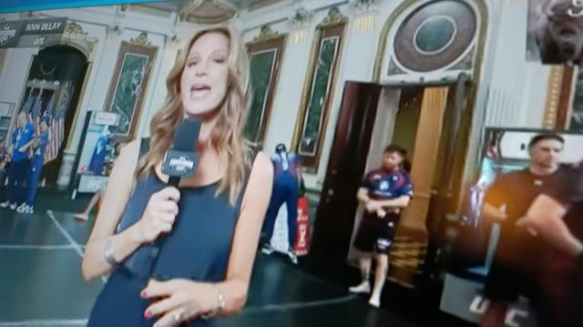 Reporter Heidi Androl stands in front of UFC fighters waiting to fight in a White House staging room.