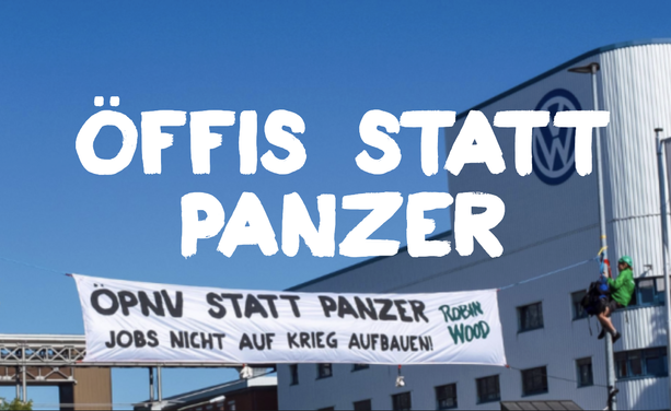 Das VW-Werk in Osnabrück. Davor ein Banner: Öffis statt Panzer. Jobs nicht auf Krieg aufbauen.