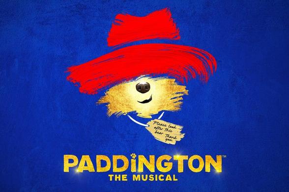 Blue poster shows Paddington’s yellow face under a bold red hat, with a small tag and gold 'Paddington The Musical' text.