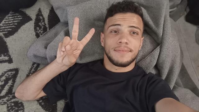 A young Palestinian man named Khaled Zeyada doing a peace sign with his fingers.