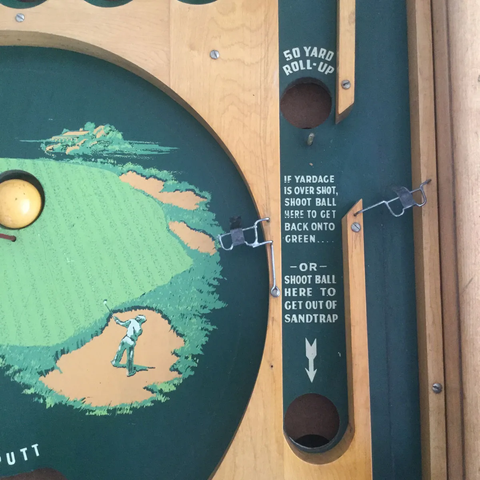 The "sand trap" kick-out gimmick of Moorman Game's Par Golf pinball.

https://www.pinrepair.com/prewar/pargolfmoorman.htm