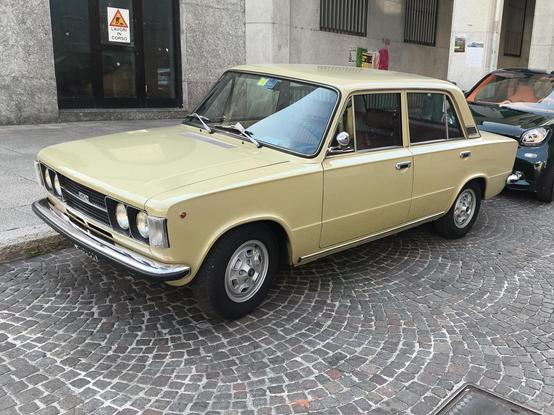 A boxy 1970's car in a rich cream colour, with almost a hint of green. Four door and twin round headlamps