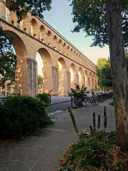 Une aqueduc Romain au soleil déclinant s'étendant à perte de vue. À son pied des vélos