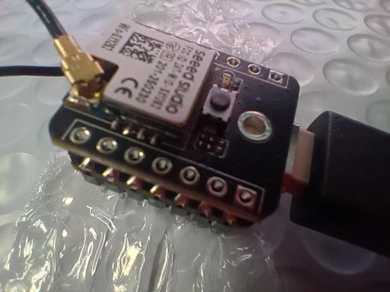 Seeed Studios ESP32S3 microcontroller, flashed with current MeshCore firmware, to work as a USB Companion device. On top is a Wio SX1262 LoRa module. Tiny coaxial cables connect tiny inefficient antennas, for bluetooth, wifi, and lora. A USB-C cable provides power and a connection to the computer.