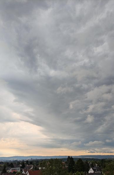 Himmel voller Wolken, unten Blick auf eine Stadt