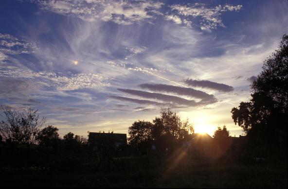 un coucher de soleil garni de nuages de haute altitude blancs et de cirrus sombres comme 4 griffes noires.
