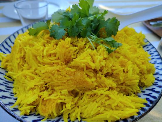 Yellow basmati rice topped with fresh coriander in a Japanese dish