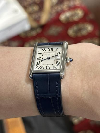 Wrist shot of a Cartier Tank in stainless steel at an angle to show how it sits.