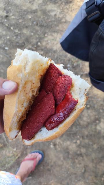 halbes Baguette mit gegrillten roten Wurstscheiben