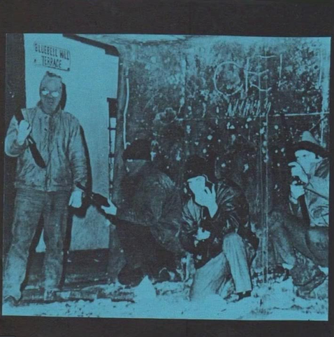 blue tinted photo of four treacherous looking fellows with guns and some masks
