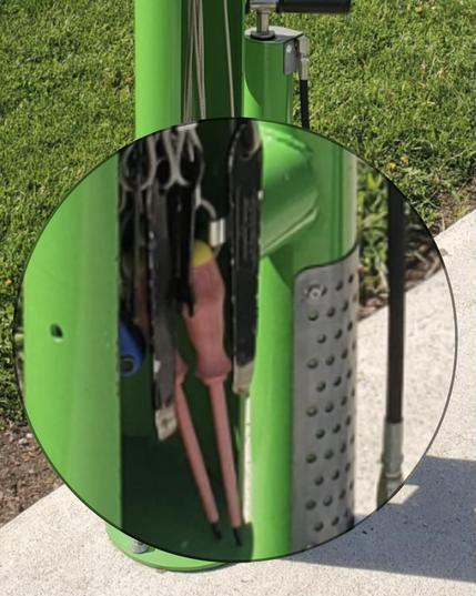Green post of sorts with cables connected to tools such as a screwdriver