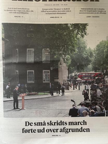 Forsiden på dagens Information. Keir Starmer står ved talepulten foran Downing Street 10, men foto er taget fra siden og langt væk fra. Det betyder at han står helt alene på en lang vej, fordi alle fotograferne står foran ham og det vil sige på række til højre i billedet. 
Billedet viser tydeligt at han også metaforisk står helt alene.