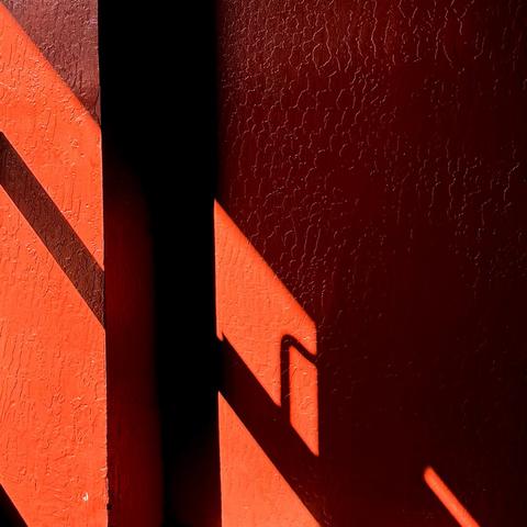 Shadow from a glass door handle on a textured orange wall