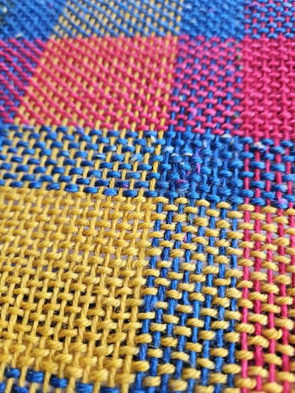 A piece of weaving in a mix of bright colours