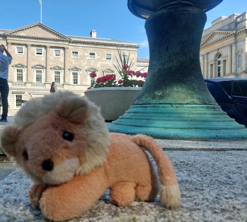 A small lion plush in front of Leinster House (the Irish parliament building).