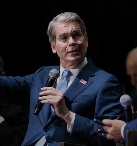 Treasury Secretary Scott Bessent looking smug with a microphone.