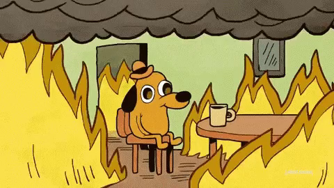 This Is Fine meme - dog sitting on chair in burning room, cup of coffee on table, chilling out