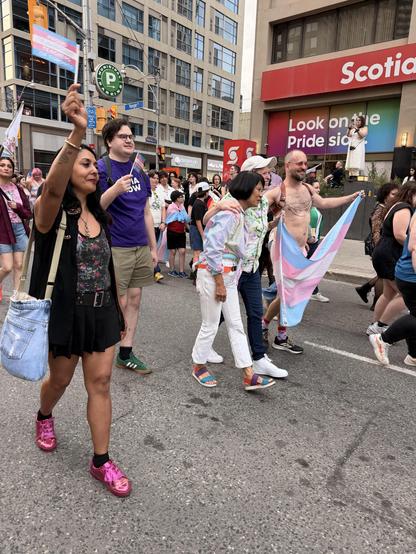 The mayor marching down the street with people carrying trans flags