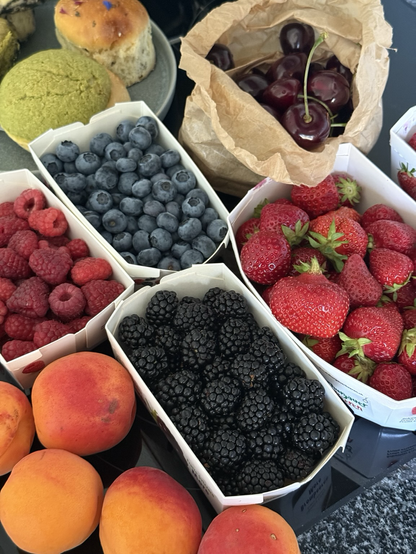 Einfach nicht zusammenrechnen, was das gekostet hat, dann geht‘s. (Schachteln mit Erdbeeren, Himbeeren, Blaubeeren, Kirschen, Aprikosen und im Hintergrund japanisches Gebäck)