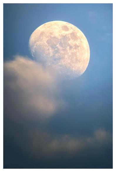 A waxing gibbous moon, with visible crater details, rises in a summer evening sky that’s still blue with fading daylight. Clouds float by below, with a puff of cloud obscuring the moon’s southwestern edge.

Shot on an iPhone 15 attached to a Celestron 130mm-aperture reflector telescope.