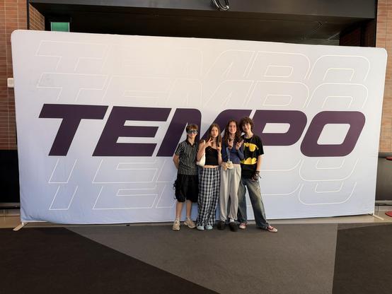 Four teens posing in front of a Tempo sign