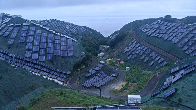 A web cam pointing at several steep hillsides with many solar panels cover the hills.

The hills are also pretty green, there's a small valley between the hills with some more panels and a couple of small buildings.