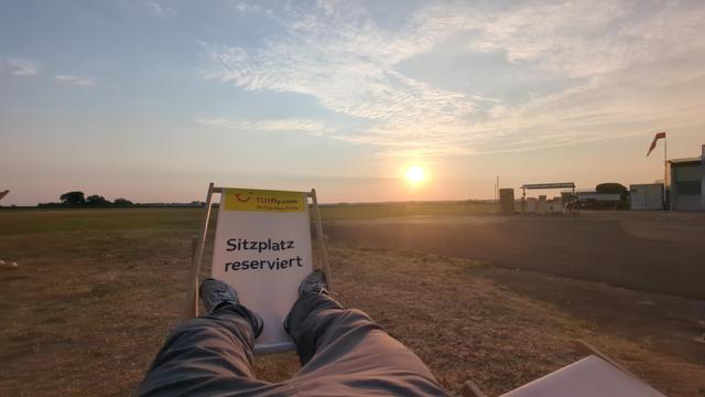 Risen sun between feet on chair.