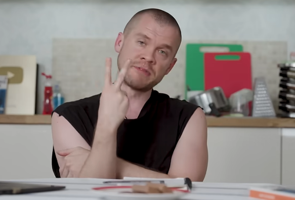 Gary sat at his kitchen table with two fingers in the air apparently flicking the Vs (though actually just enumerating options)