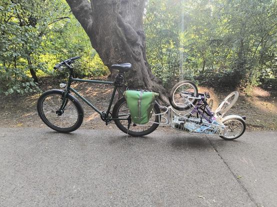 Ein Fahrrad mit BobYak Fahrradanhänger. Darauf befindet sich ein Kinderfahrrad auf dem Kopf stehend