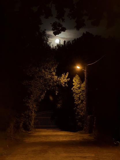 A dark street ar night with glowing Moon in the sky