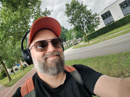 cheeky selfie of this part-wookie with a baseball cap, sunglasses, headphones and a big smile.
